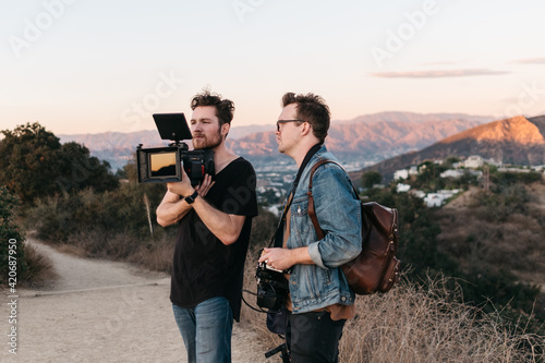 A cinematographer and director film during golden hour