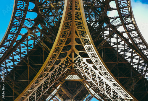 Inside the Eiffel Tower in Paris, France. View to the inside of Eiffel Tower. Big symetrical building. Close up shot in the morning. Blue sky with a sunny weather