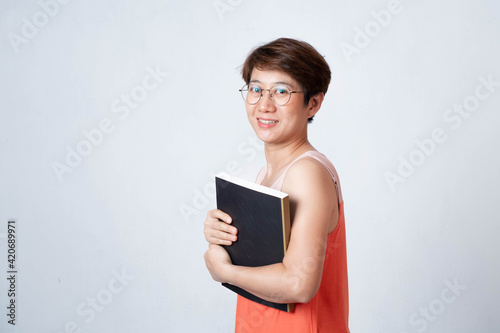Portrait of an Asian short haired woman holding a book on a white background