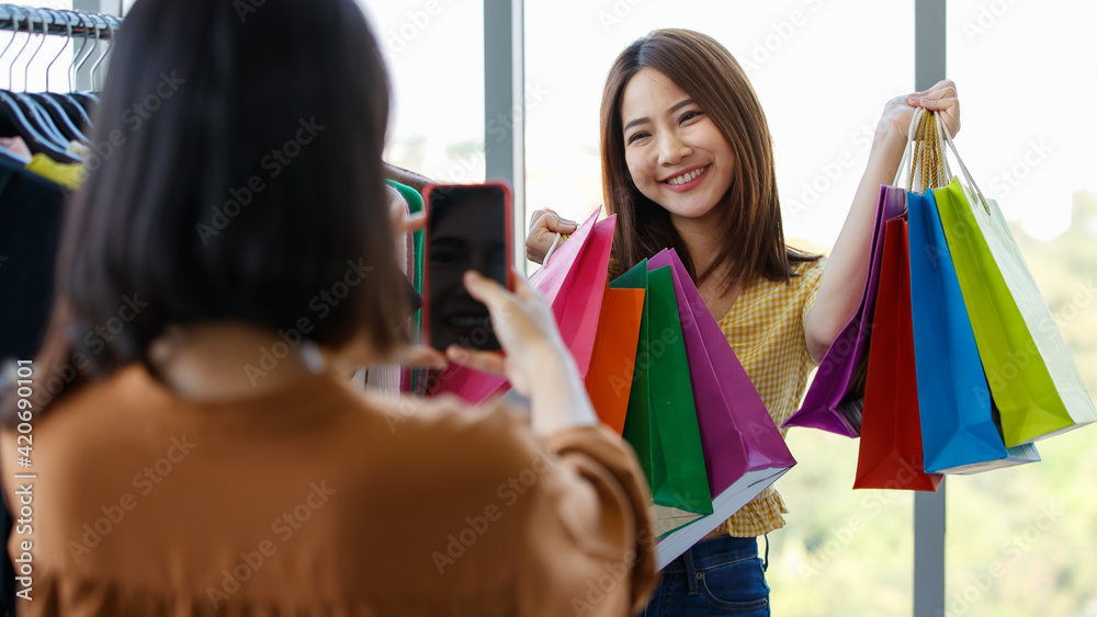 Blurred woman taking photo of girlfriend in shop Blurred woman taking photo of girlfriend in shop