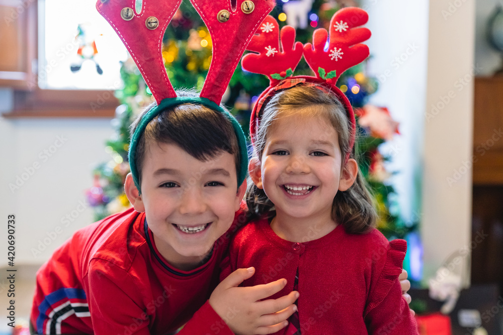 Happy Siblings in front of a Christmas Tree Happy Siblings in front of a Christmas Tree