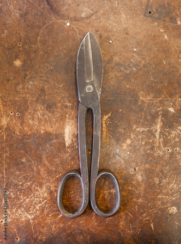 A pair of scissors in a jewellery factory seen on an old wooden workbench