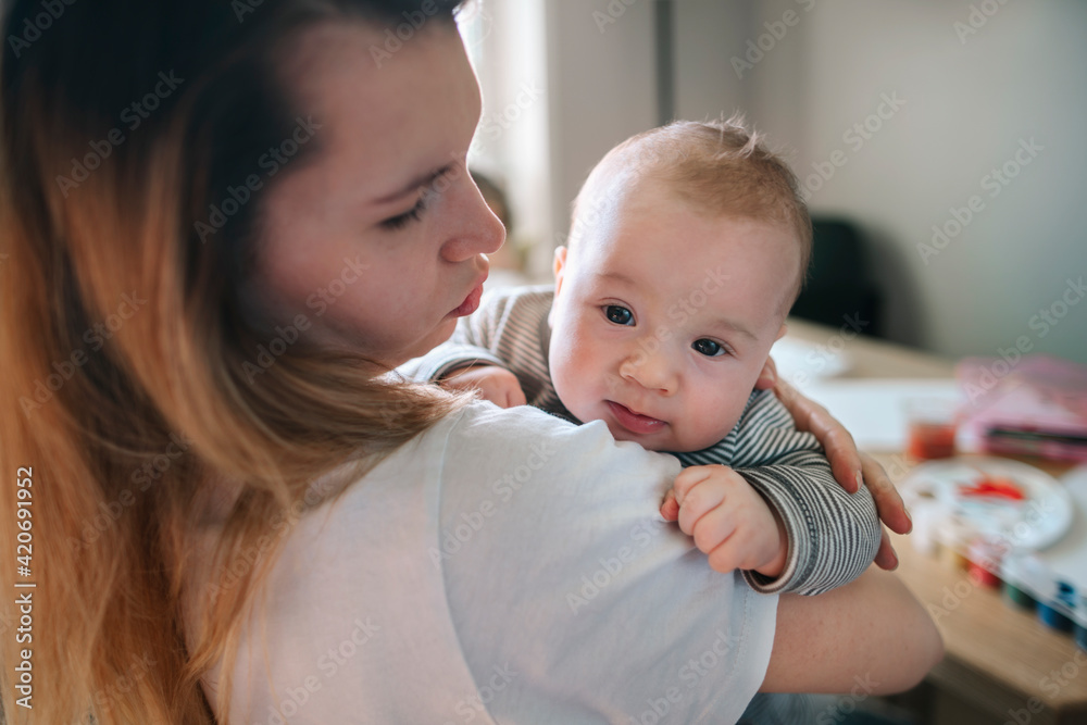 A young mother with a newborn baby in her arms. A young mother with a newborn baby in her arms.