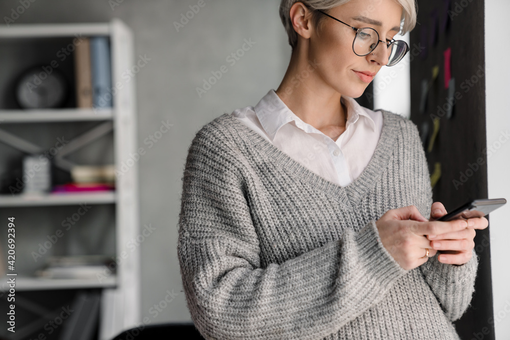 Smiling attractive young woman using mobile phone Smiling attractive young woman using mobile phone