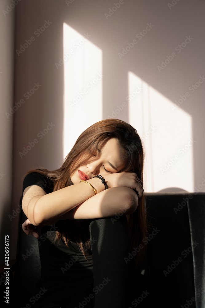 A woman is sleeping with a ray of sunlight on her face A woman is sleeping with a ray of sunlight on her face