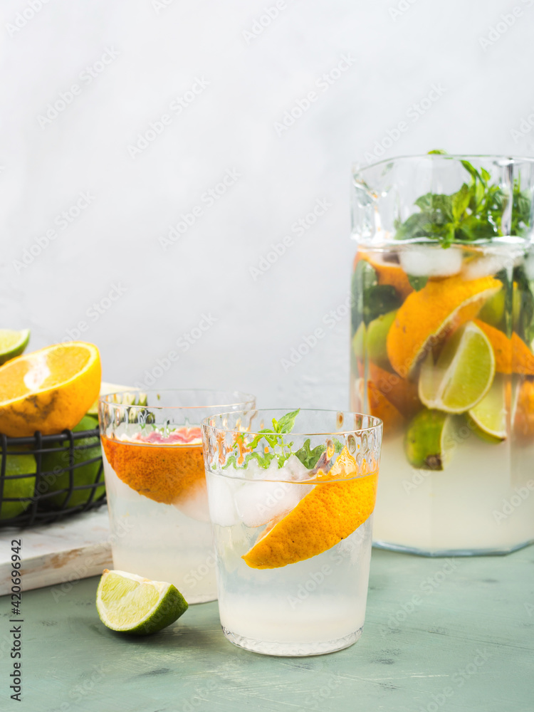 Fototapeta premium Fresh summer citrus drink with ice on green