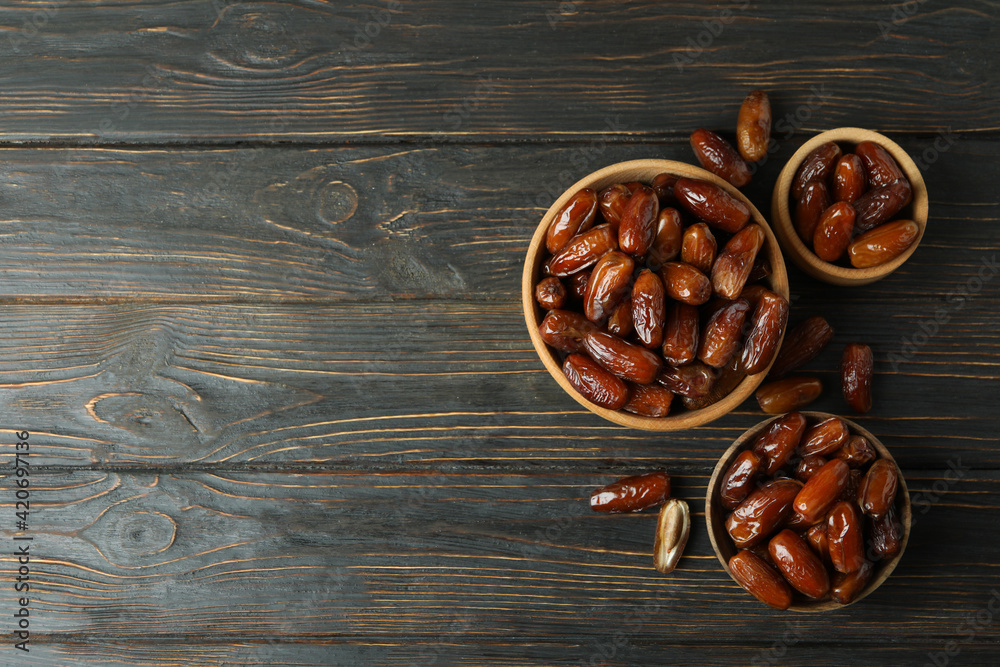 Fototapeta premium Bowl with dried dates on wooden table