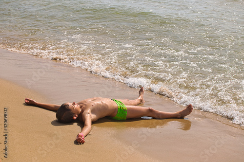 child swims in the sea waves on the beach