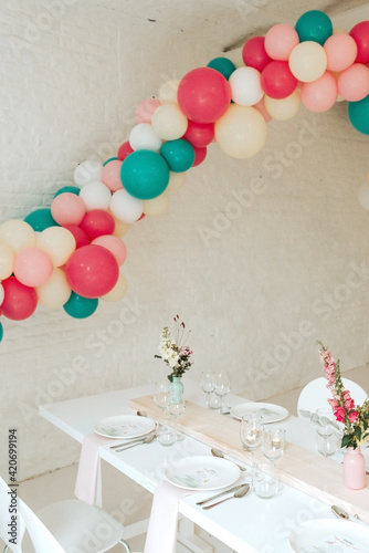 Wedding table with balloon arch in pastel colored theme photo