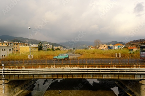 Vecchia panda 750 verde attraversa un vecchio ponte arrugginito ad Albisola marina (SV) dando una impressione di desolazione vintage e decadente photo