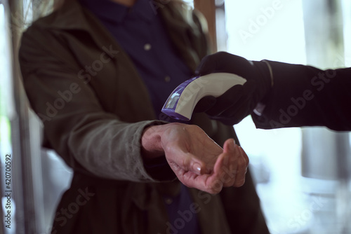 Female traveller having her temperature checked with a contactless thermometer