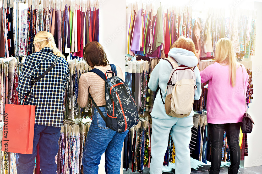 Women choose fabrics in textile store