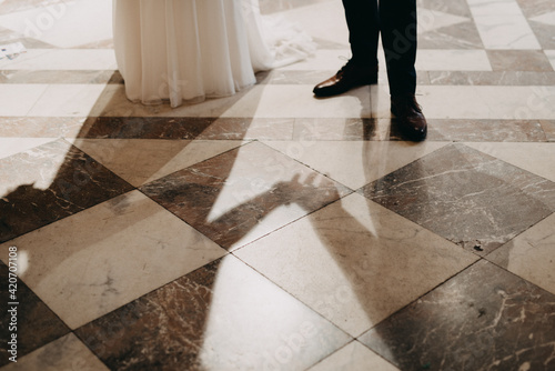 Shadow of bride and groom holding hands in town hall photo