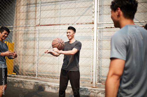 young asian basketball players having fun on outdoor court