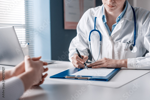 Doctor writing a medical prescription photo