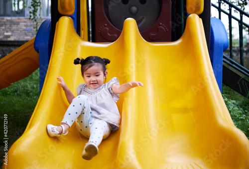 Cute little Asian girls playing on the slide in the farm photo