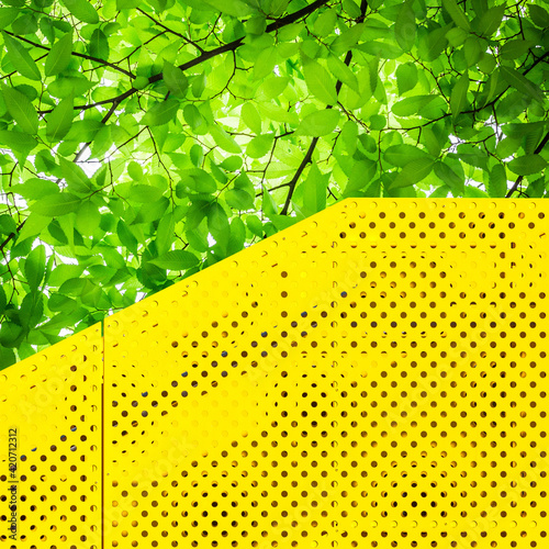 Industrial metal detail and green tree leaves