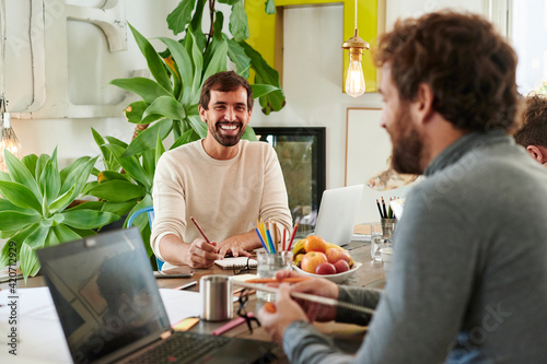 Smiling designer talking with coworkers