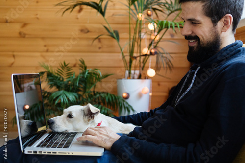 Man working from home on his laptop with his dog