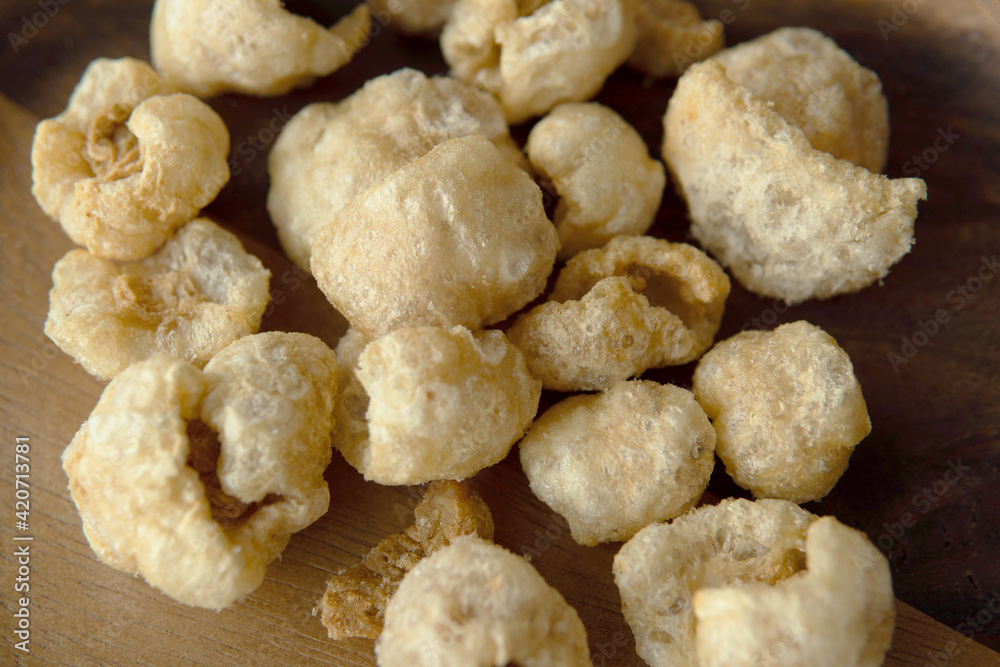 Close-up Pork crackle in wooden plate background Close-up Pork crackle in wooden plate background