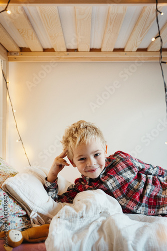 Toddler in Christmas pajamas smiling at camera