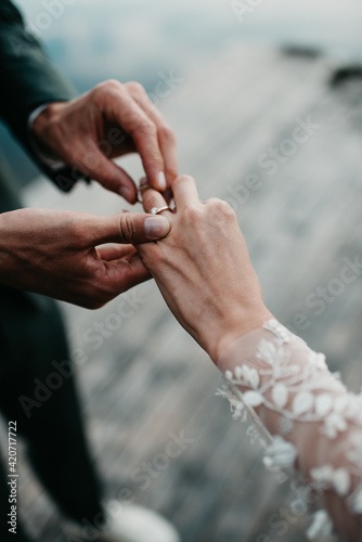 groom ringing bride with golden diamond ring photo