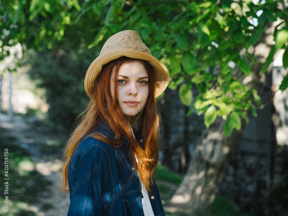 Happy traveler in hat and denim jacket outdoors in countryside
