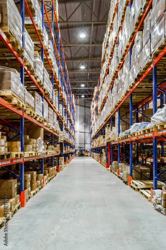 Interior of a modern warehouse storage of retail shop with pallet truck near shelves © Roman