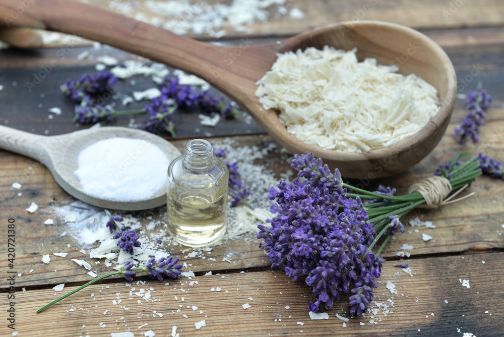 spoon full of flakes of soap with essential oil and bunch of lavender with bicarbonate on wooden background spoon full of flakes of soap with essential oil and bunch of lavender with bicarbonate on wooden background