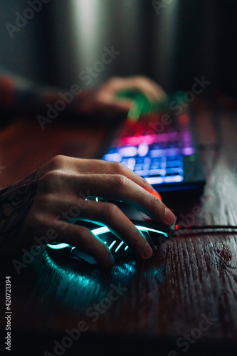 Hand on neon gaming computer mouse photo