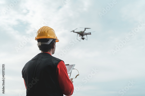 Male engineer monitoring construction site with drone - Technology and industrial concept