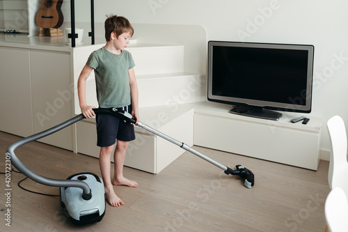 A young boy is cleaning the room. photo