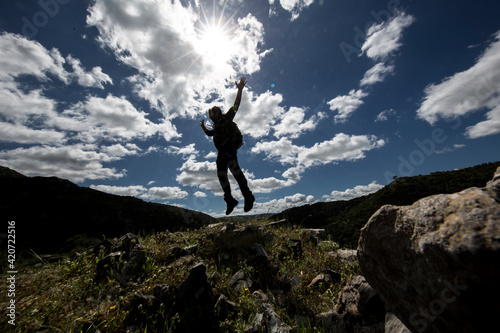 Uomo in controluce salta immerso nella natura © alex.pin