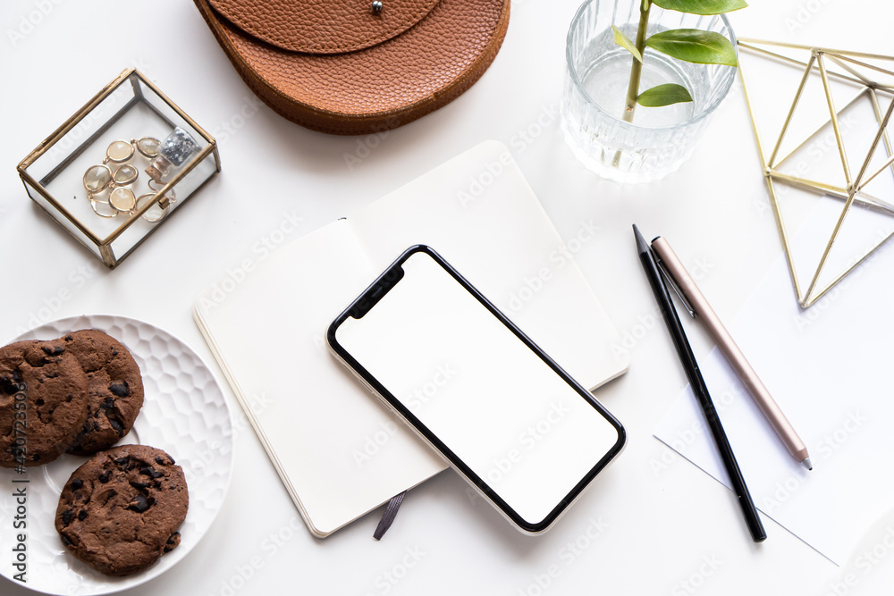 White home office tabletop with smartphone mock-up, coffee cup and notepad White home office tabletop with smartphone mock-up, coffee cup and notepad