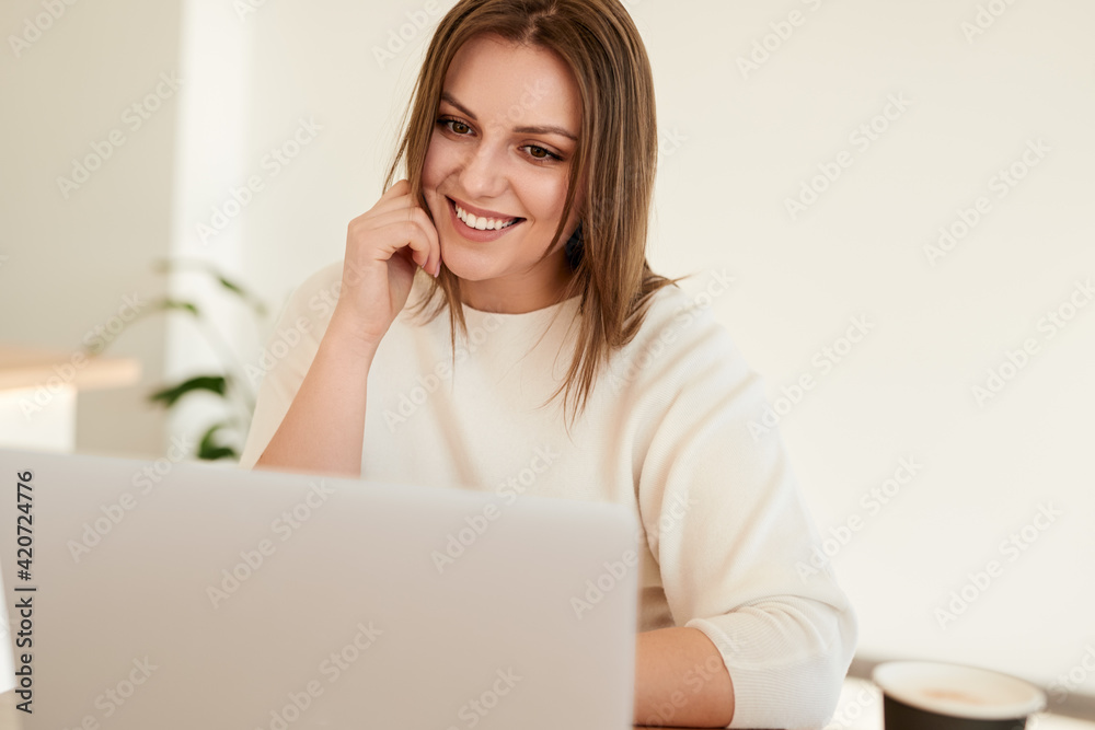 Happy young woman working on laptop in cafe Happy young woman working on laptop in cafe