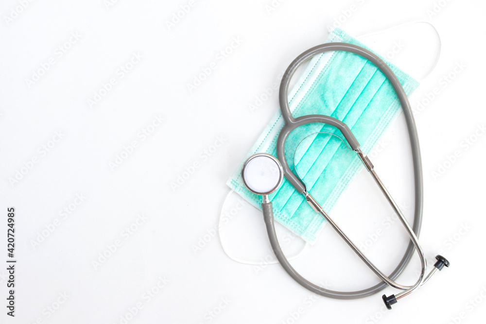 Stethoscope and green medical mouth mask, face mask protection against pollution, virus, flu. Health care and medical concept on white background. Stethoscope and green medical mouth mask, face mask protection against pollution, virus, flu. Health care and medical concept on white background.