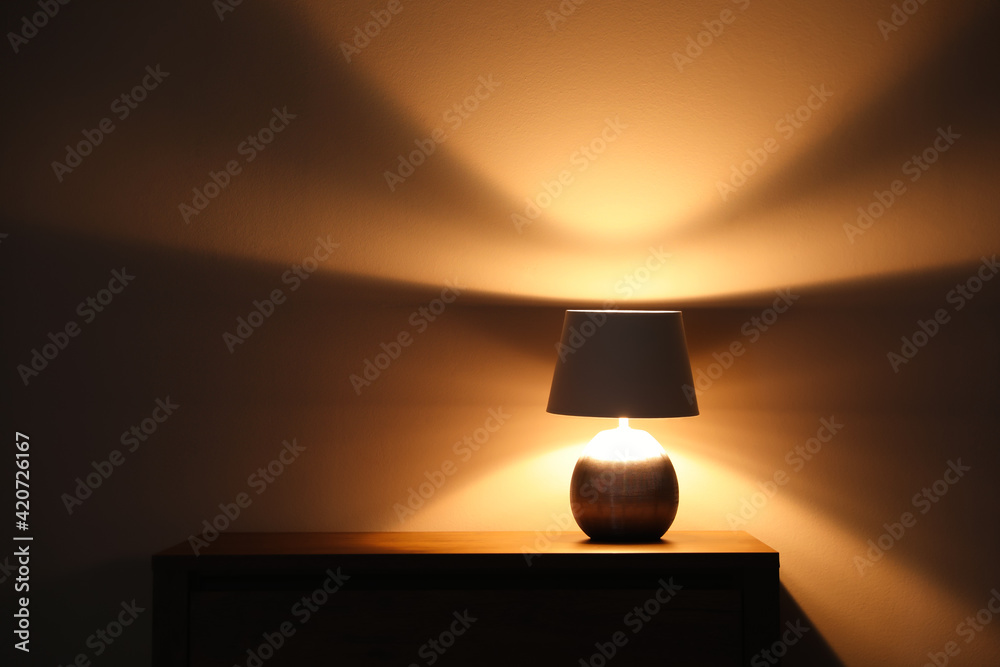 Stylish glowing night lamp on table in room. Space for text Stylish glowing night lamp on table in room. Space for text