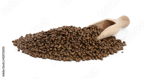Buckwheat tea granules and wooden scoop on white background