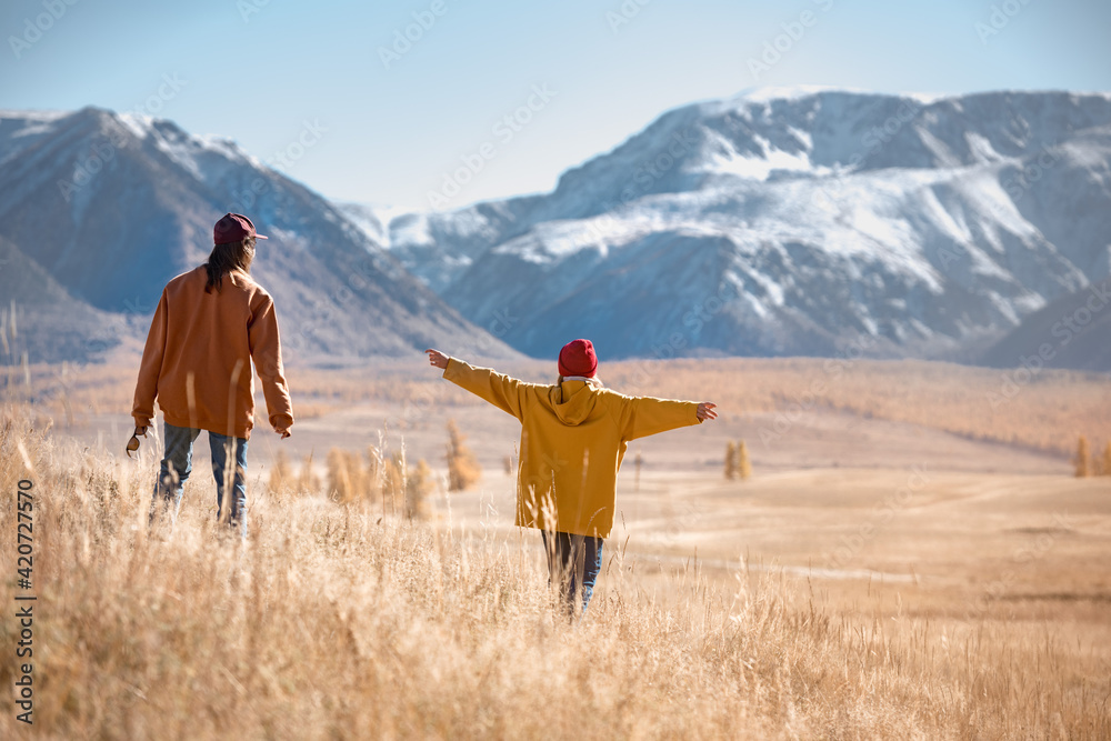 Two hikers walks in mountains without backpacks - obrazy, fototapety, plakaty 