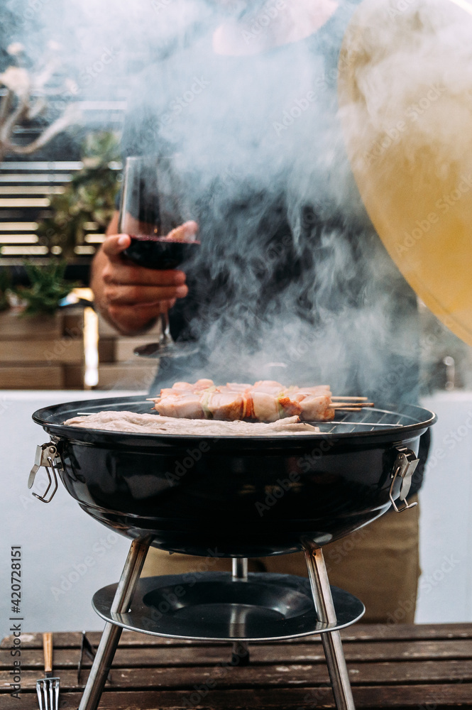 Crop man cooking meat on grill on terrace Crop man cooking meat on grill on terrace