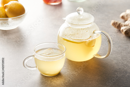Glass cup and teapot of infusion photo