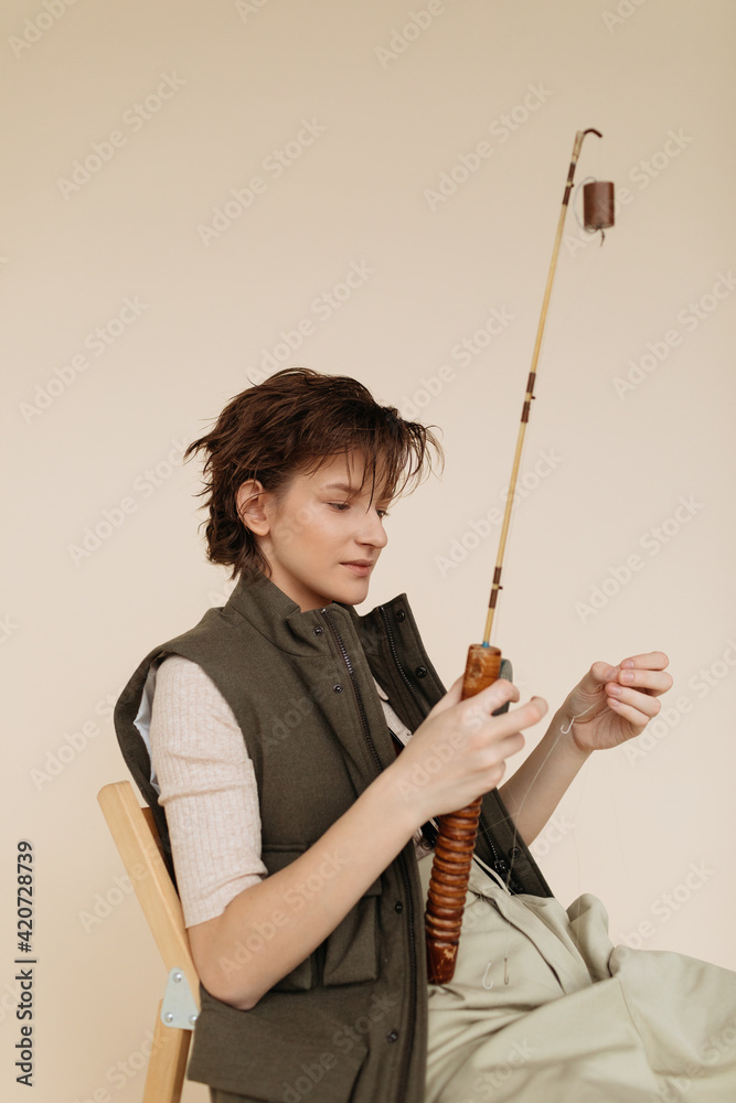 Female angler preparing rod for fishing Female angler preparing rod for fishing