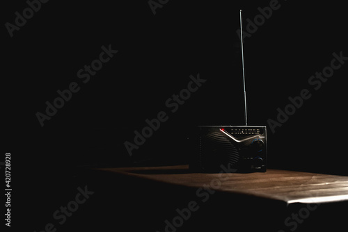 Transistor radio on the table in black backdrop.