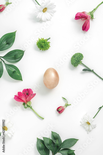 Fototapeta Naklejka Na Ścianę i Meble -  2021 Creative Easter flat lay pattern with pink spring flowers and green leaves on minimal white background. Colorful floral nature blooming concept. Gold Easter egg.