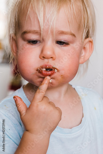 little girl stuffing mouth full of birthday cake photo