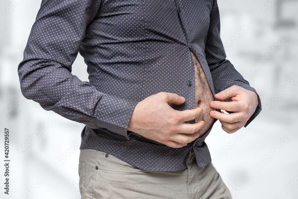 Fat belly of man which does not fit under the shirt Fat belly of man which does not fit under the shirt