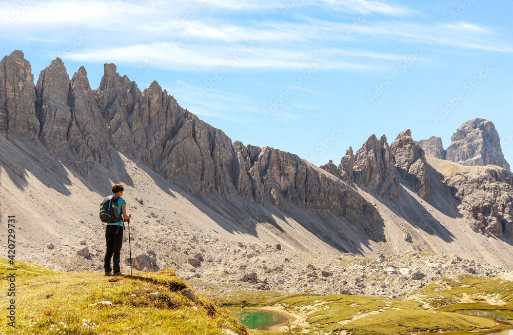 Lonely hiking woman looking at scenic mountains Lonely hiking woman looking at scenic mountains