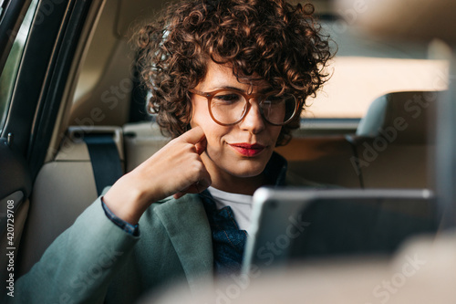 A Woman in the Car Using a Digital Tablet photo