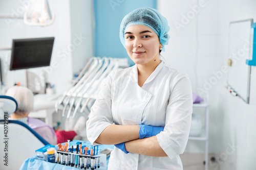 Woman dental surgeon crossing arms in clinic