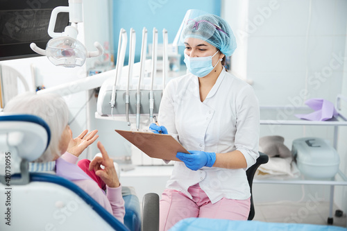 Joyful dental worker recording the patient story photo